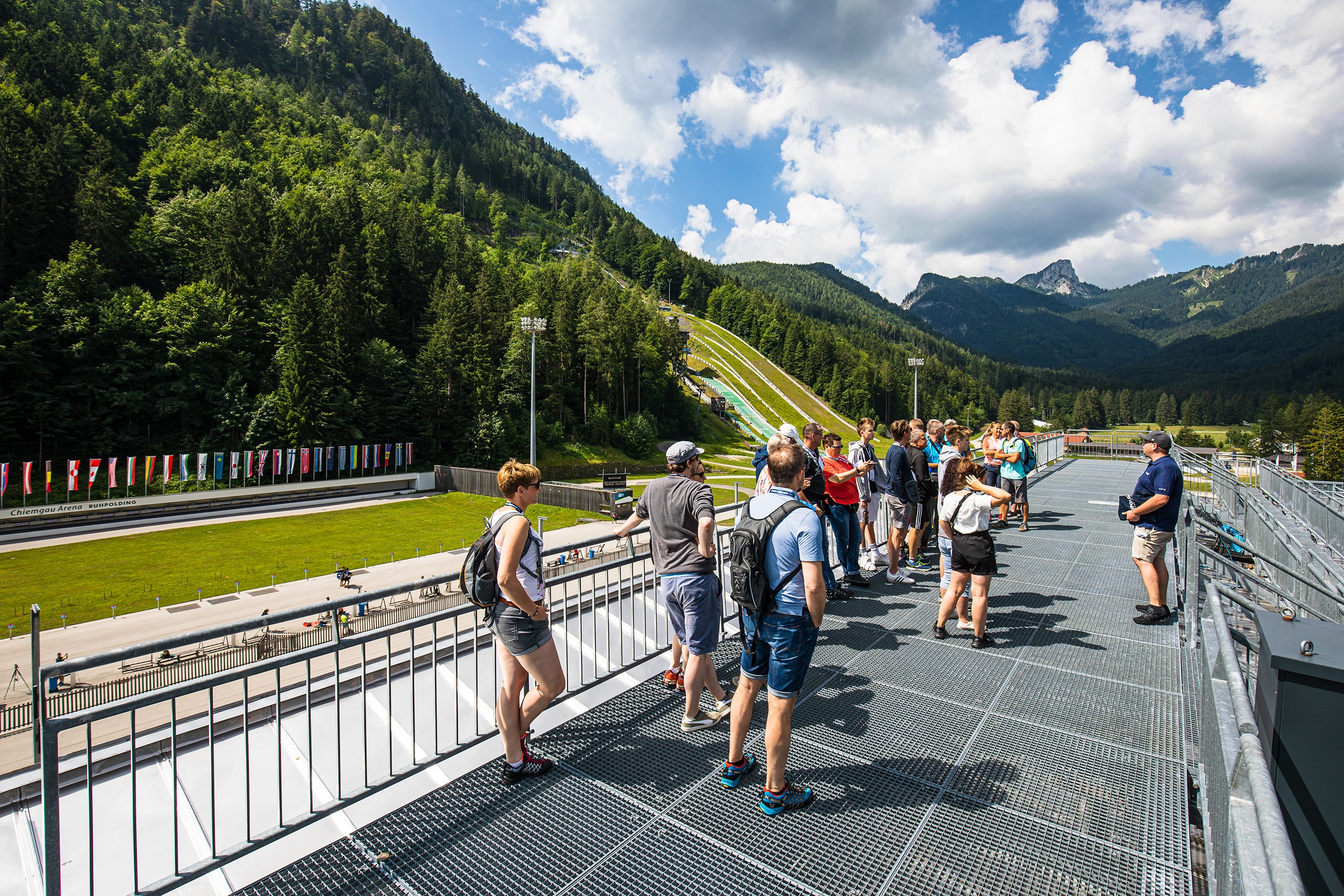 Gruppe bei der Arena-Tour auf der Aussichtsplattform mit Blick auf Stadion und Skisprungschanze.