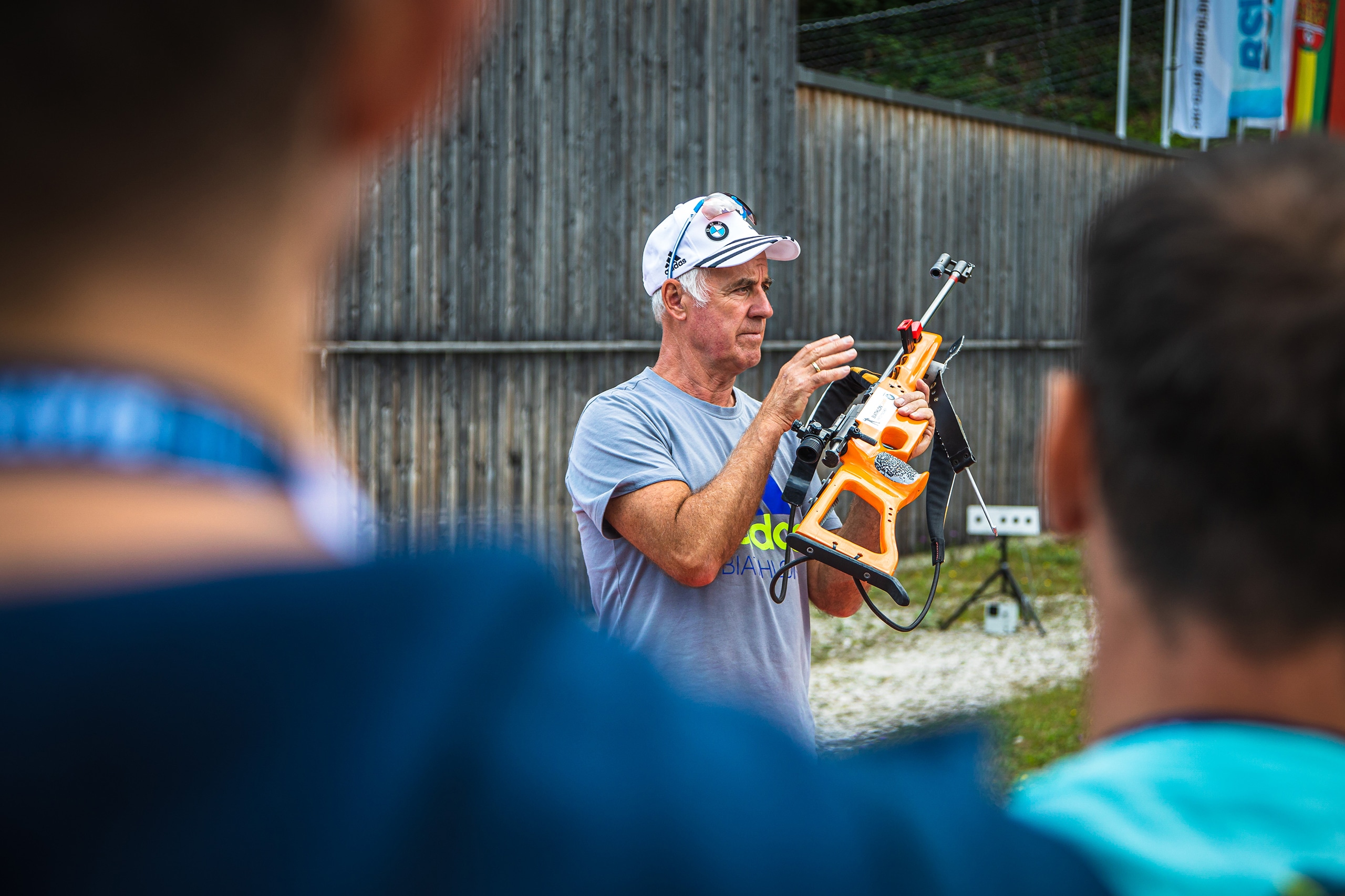 Trainer zeigt Details am Biathlongewehr während der Einweisung zum Biathlonschießen.