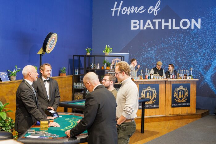 Spielbank-wird-offizieller-Partner Vertreter der Spielbank Bad Reichenhall und der Chiemgau Arena beim Partnertermin vor Bar und Spieltisch.